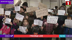 В логистическом центре на границе маленькие беженцы устроили митинг с плакатами
